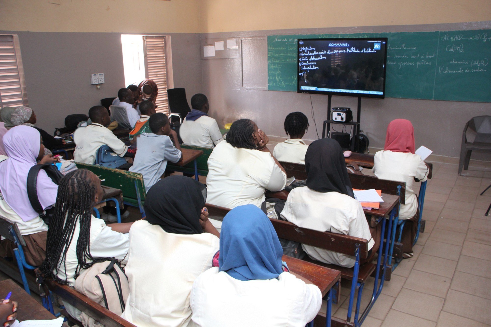 Élèves d’une école partenaire suivant un cours ISS sur grand écran